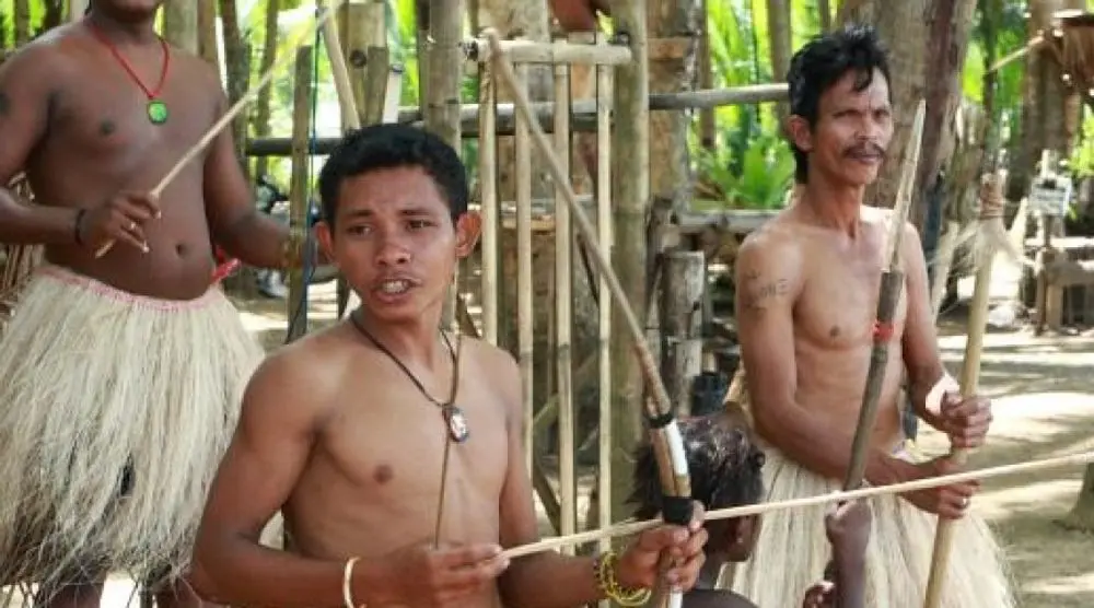 Palawan men in grass skirts with blowpipes