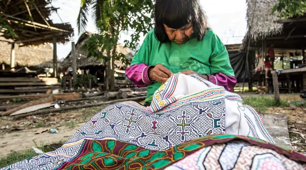 Woman embroidering geometric textile patterns