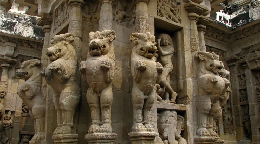 Carved lion pillars along a temple wall