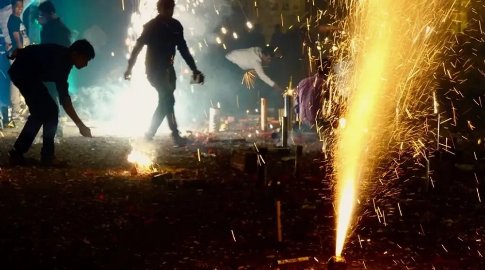 Fireworks being lit on a street at night