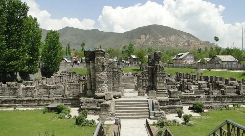 Temple ruins on a lawn below the hills