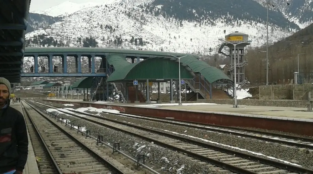 Railway station with snow-covered hills behind