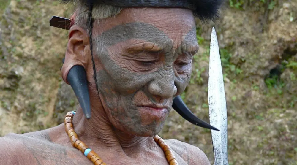 Tattooed Konyak elder with traditional ornaments