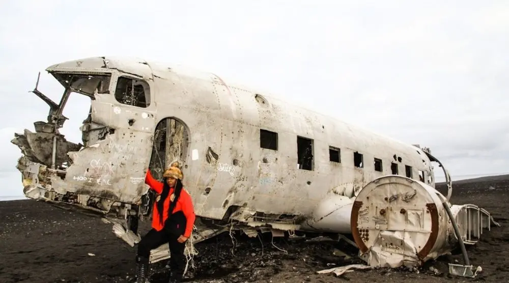 Hiker beside the wreck of a crashed aircraft