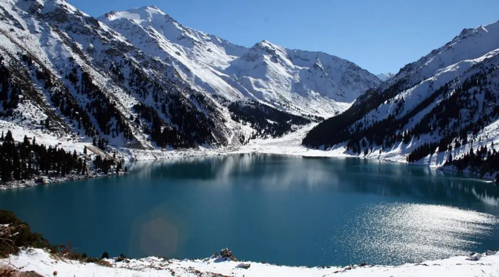 Turquoise lake among snowy mountains