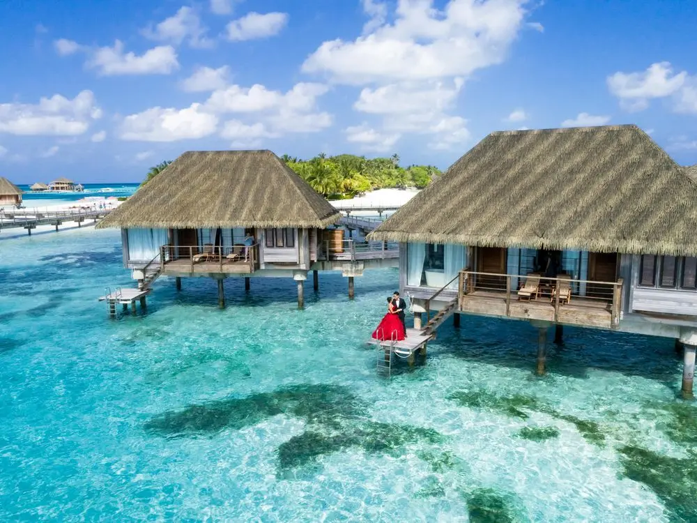 Couple on the steps of an overwater villa