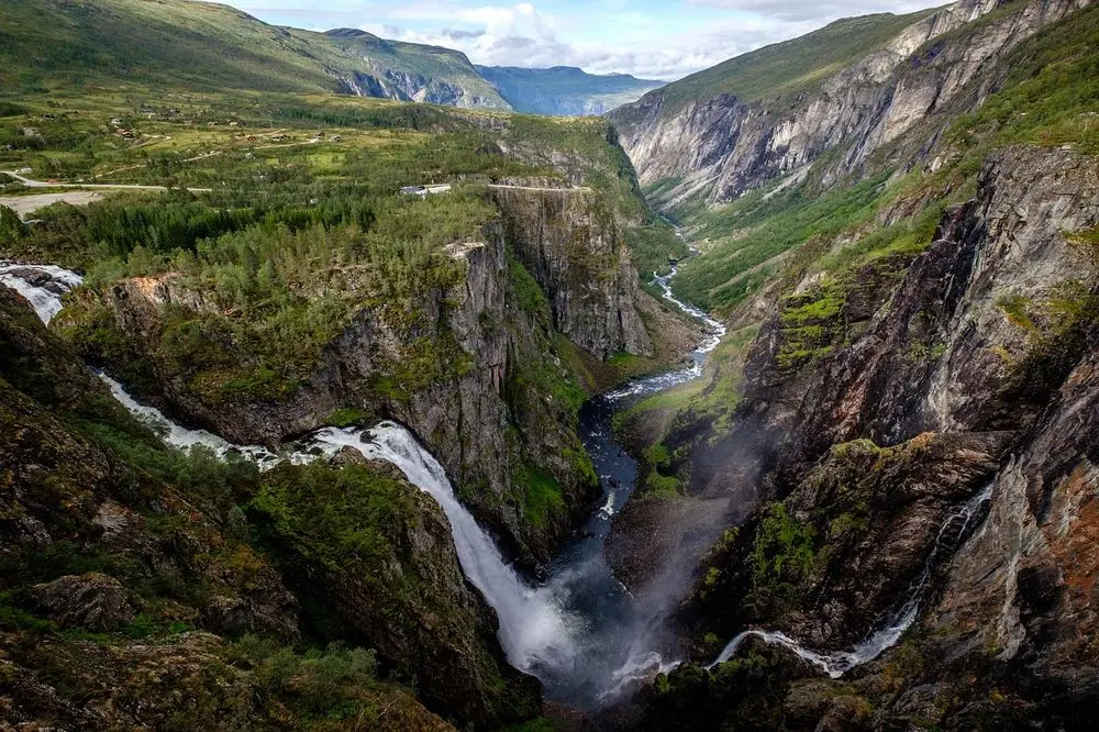 Waterfall plunging into a deep green gorge
