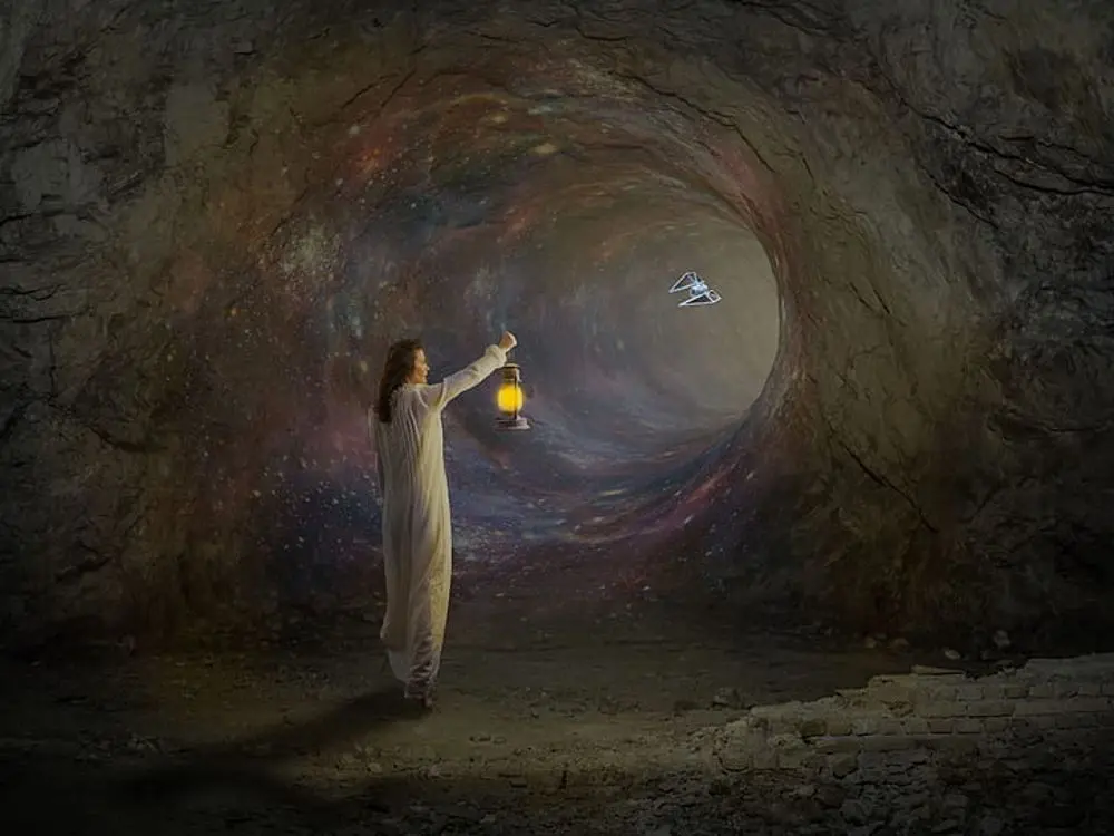 Woman with a lantern inside a dark tunnel