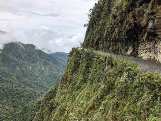 Narrow cliff-edge road through green Bolivian mountains