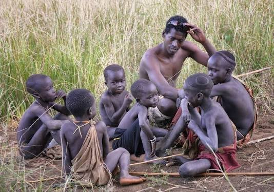Suri children sitting together in long grass