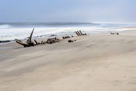 Shipwreck half-buried on a beach, Skeleton Coast