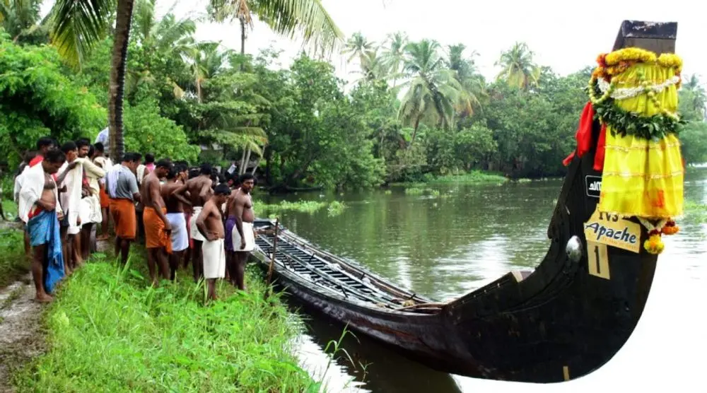 Crowd beside a snake boat on a Kerala river