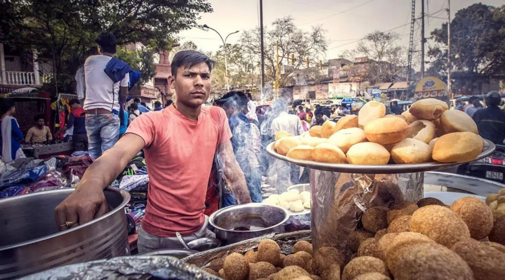 Street vendor frying snacks at a Delhi stall