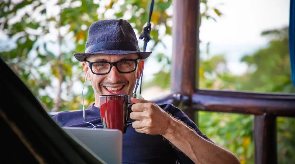 Smiling man with a mug and laptop