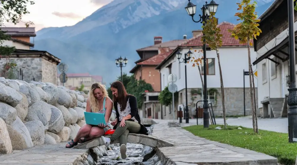 Friends working on laptops in a mountain town