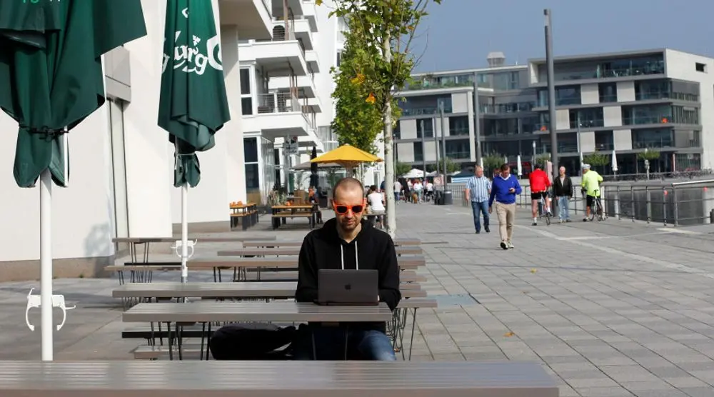Man working on a laptop at a seafront café