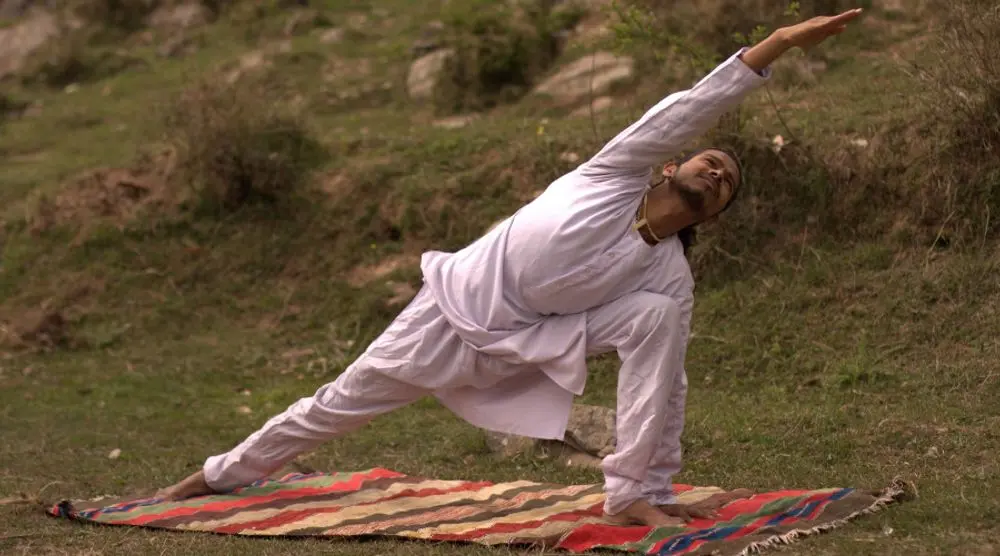 Man in a side-angle yoga stretch outdoors