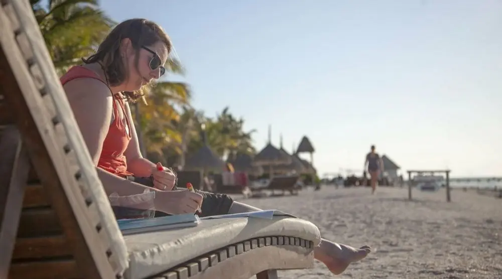 Woman writing on a beach lounger