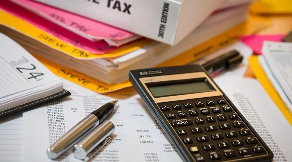 Tax papers, calculator and pen on a desk