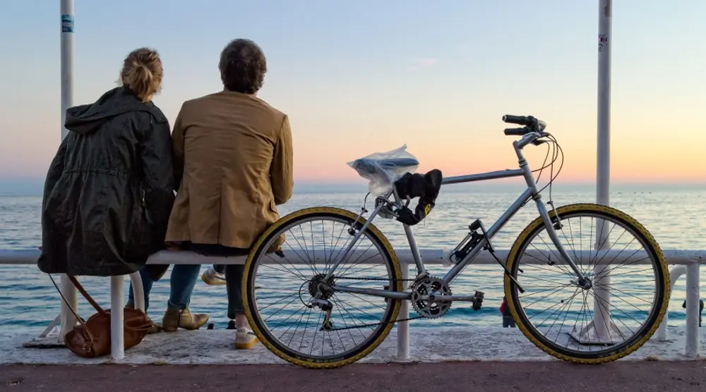 Couple sitting by the sea with a bicycle