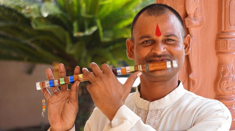 Smiling man playing a flute