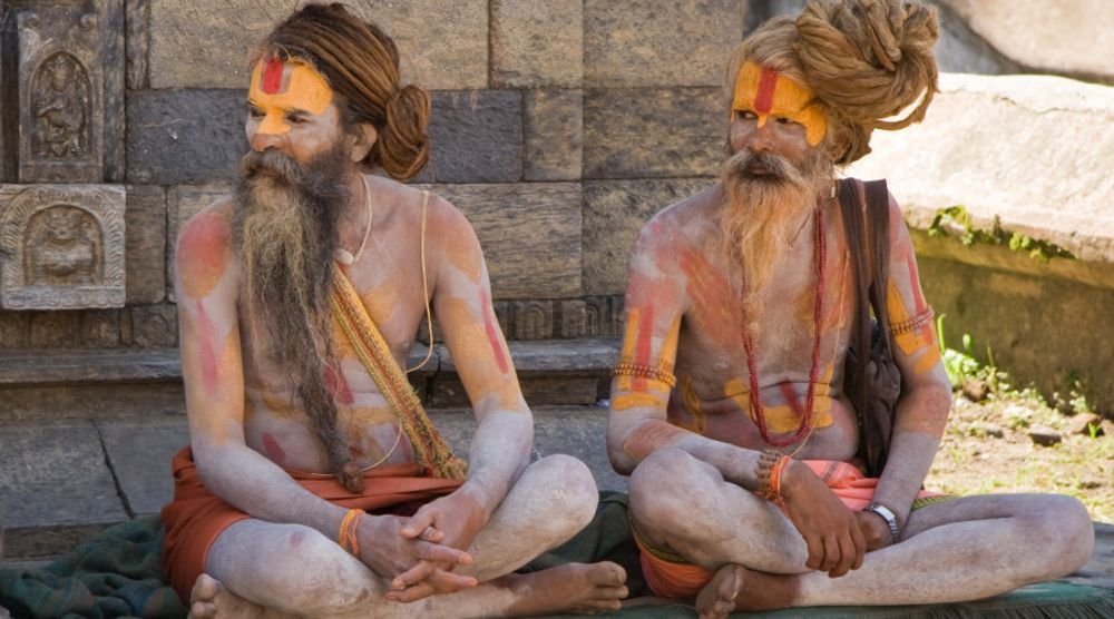 Two ash-smeared sadhus sitting cross-legged