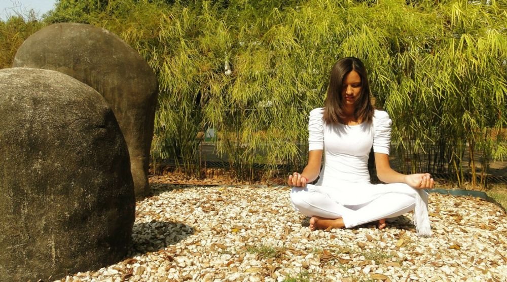 Woman meditating among boulders