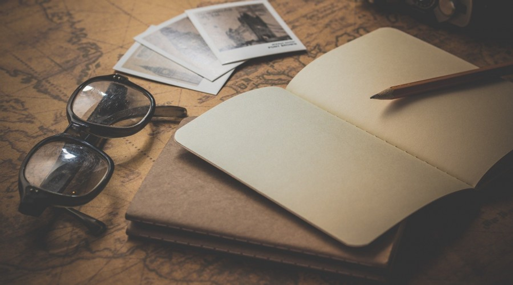 Notebook, glasses and photos on a desk
