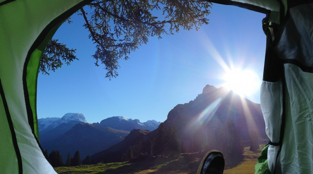 Sunlit mountain view from inside a tent