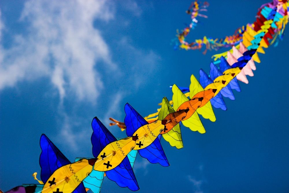 String of colourful kites in a blue sky