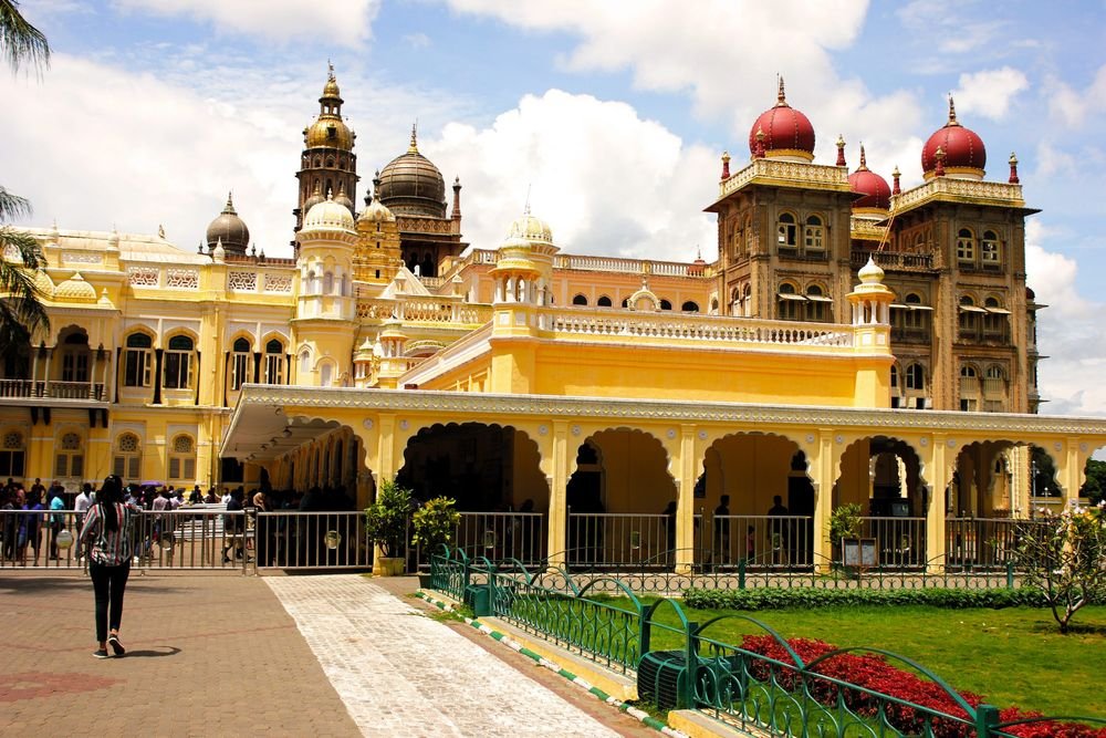 Yellow palace building with gardens in Mysore