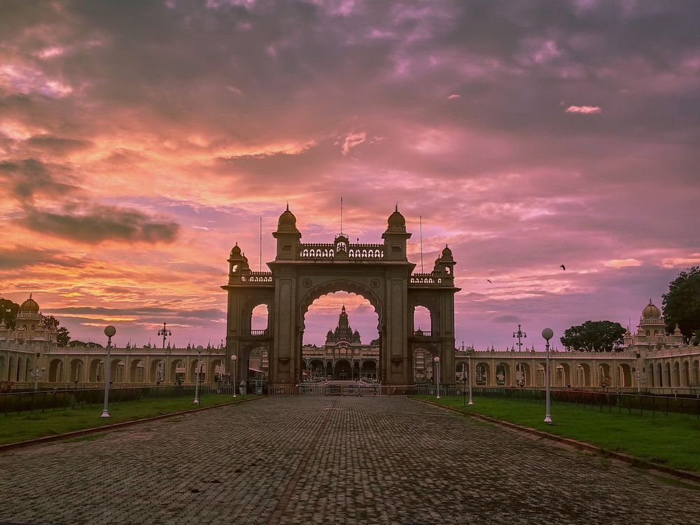 Palace gateway under a pink sunset sky