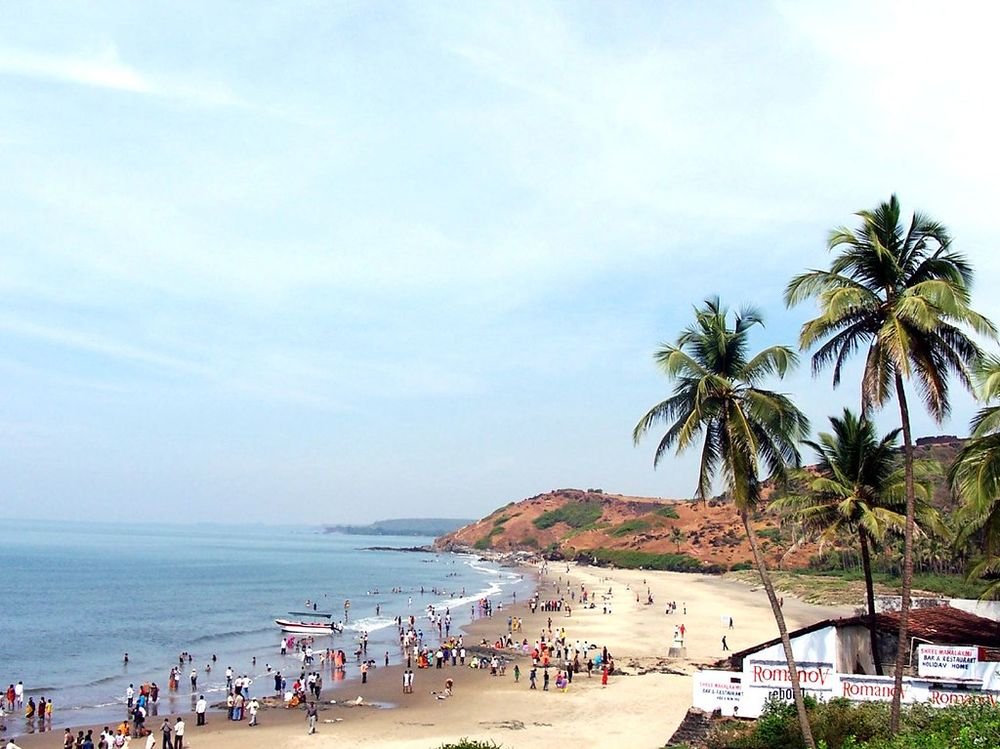 Busy Vagator Beach below red cliffs