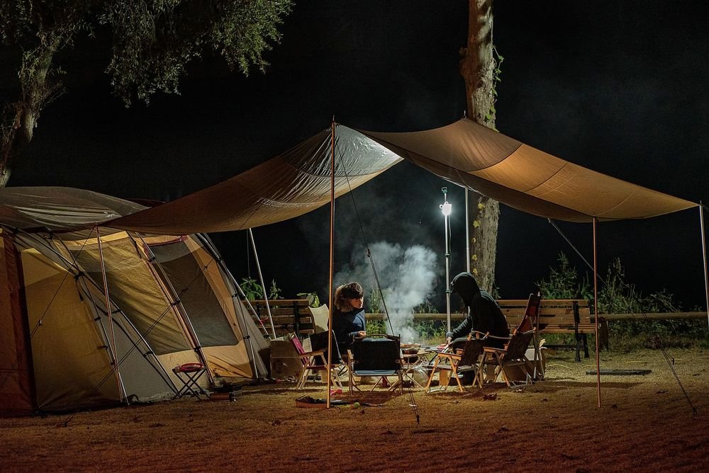 Tents lit up at a campsite at night